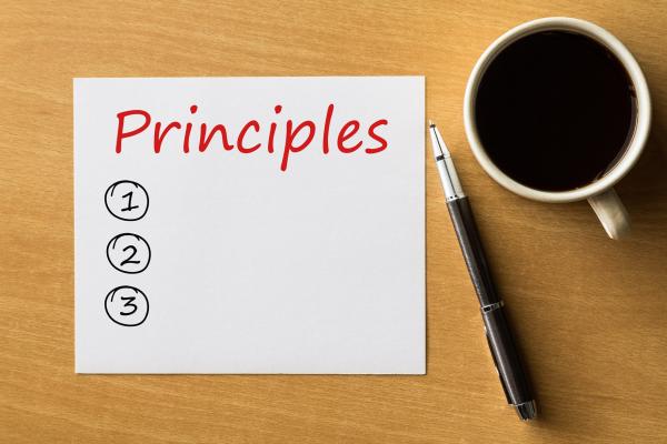 List titles principles with coffee and pen