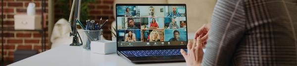 Laptop on desk showing multiple attendees at a webinar