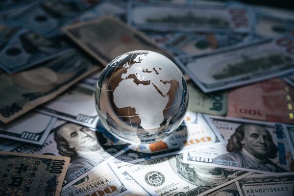 A crystal globe on various currency