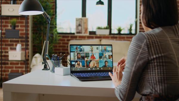 Image shows a person watching webinar on a laptop
