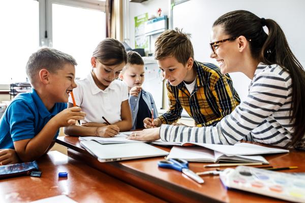Classroom with teacher helping school children with their work