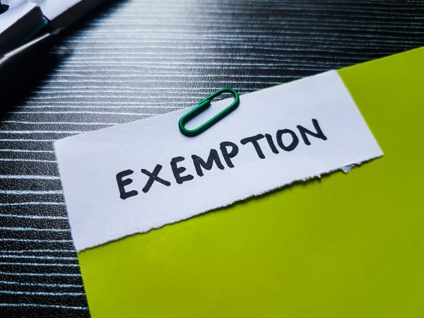 Note reading "exemption" paperclipped to a document