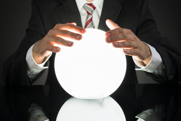 Man in stripy tie with hands on glowing crystal ball