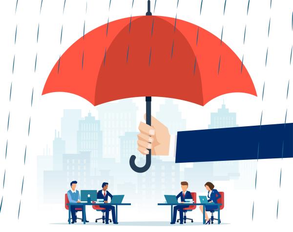Giant umbrella covers four people sat at desks, protecting them from rain