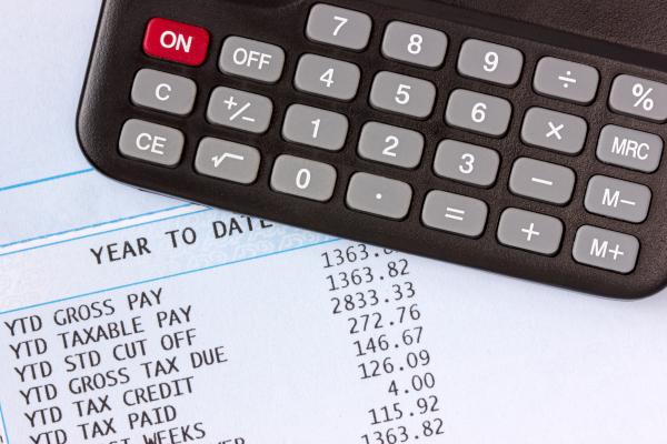 Payslip on desk with a calculator on top of it