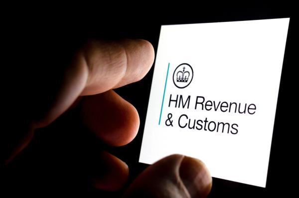 HMRC logo on a white touchscreen with hand operating it