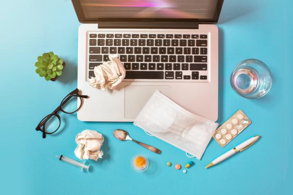 Laptop surrounded by home-medical supplies such as tablets and tissues