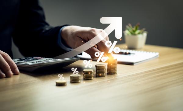 Piles of coins of increasing heights on a desk with a virtual arrow pointing upwards