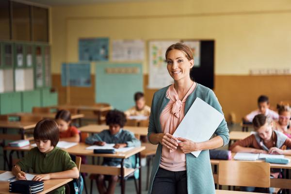 Smiling teacher in classroom of children