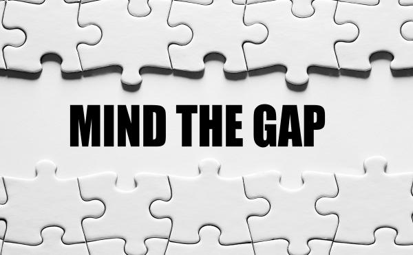 Completed jigsaw puzzle with one row missing, revealing the words "mind the gap"