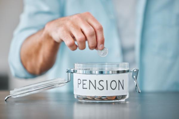 Man dropping coin into small glass jar labelled 'Pension'