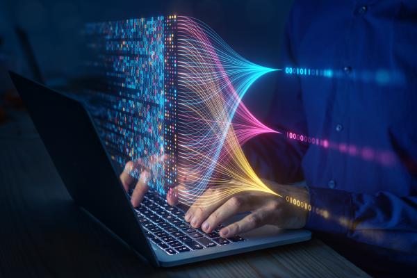 Laptop with coloured graphics coming out of the screen visualising data extraction