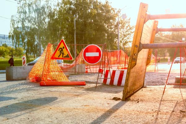 A street scene with roadworks in the middle and a no entry sign