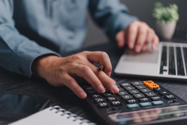 Man using laptop and calculator