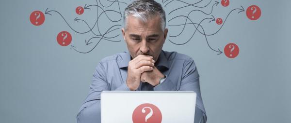Man using laptop with question marks surrounding him, linked from his head by arrows