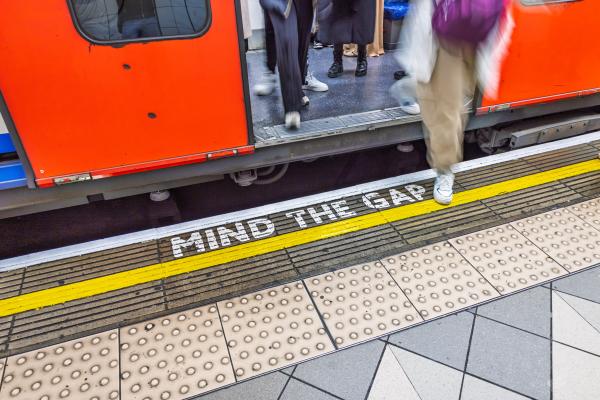 London underground scene with close up of "Mind the gap" warning on the platform edge