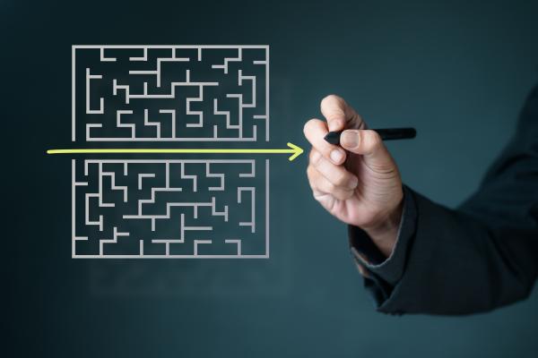 Virtual image of a maze, with hand drawing a yellow arrow straight through the middle as the simplest route