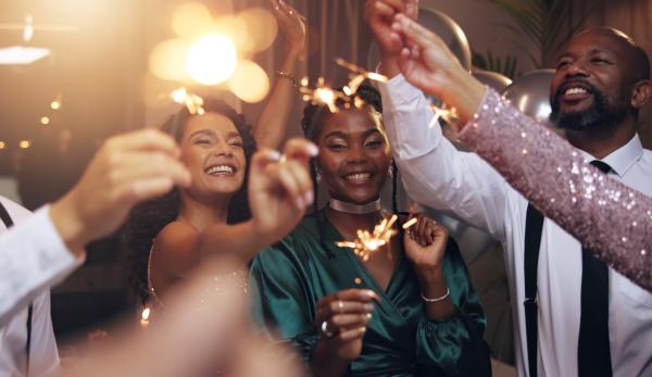 Party scene with well dressed people celebrating and holding sparklers
