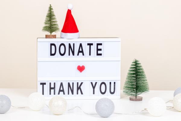 Sign reading "Donate" and "thank you" surrounded by Christmas decorations
