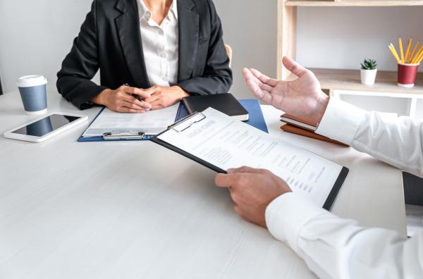 A meeting taking place, with clipboards