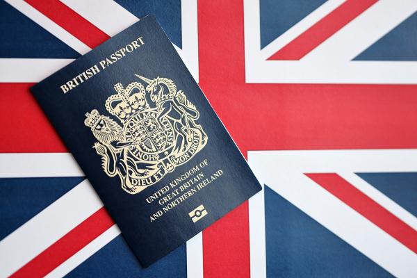 Blue British passport against a Union Jack background