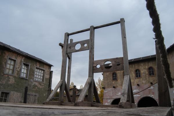 Two sets of medieval stocks with head holes and two arm holes in a wooden frame