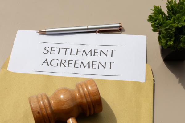 Hammer and letter saying Settlement Agreement