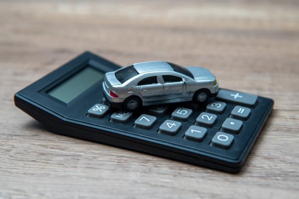 Silver toy car placed on top of a calculator