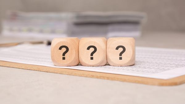 Three wooden blocks with a question mark on each lined up on a form