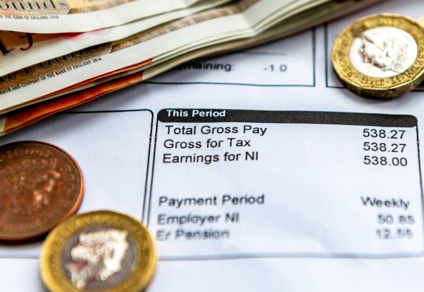 Payslip with coins and banknotes resting on it