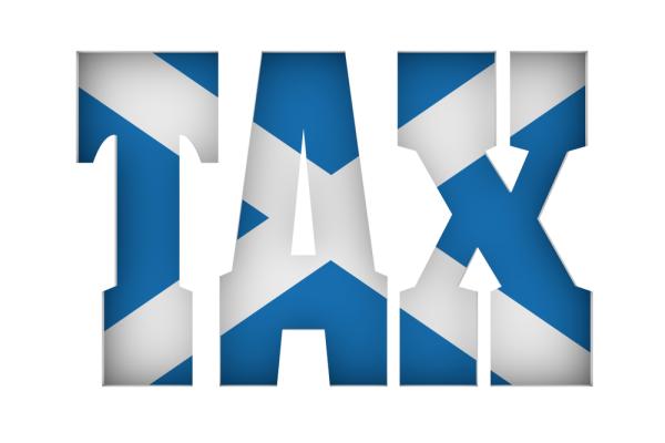 Cutout word TAX with flag of the Scotland on backdrop