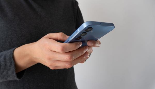 Close up of person using a blue smartphone, held in both hands