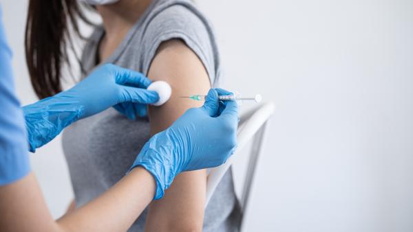 Nurse giving injection into woman's arm